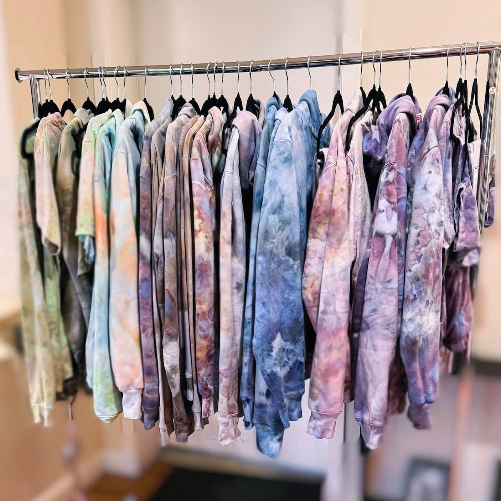 Rack of ice-dye apparel in various muted colors