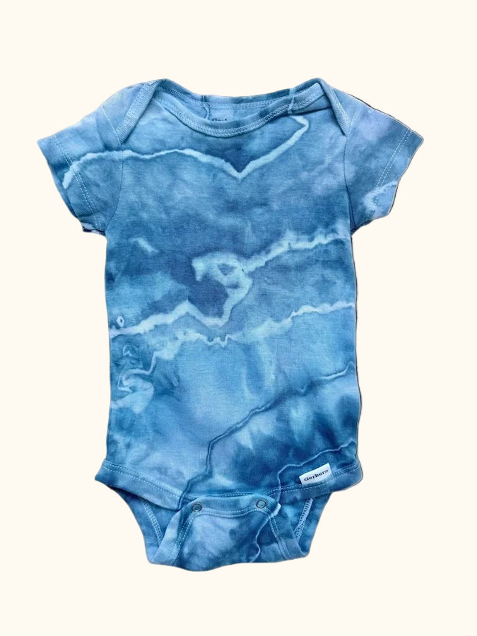 Blue ice-dye baby onesie on a light background