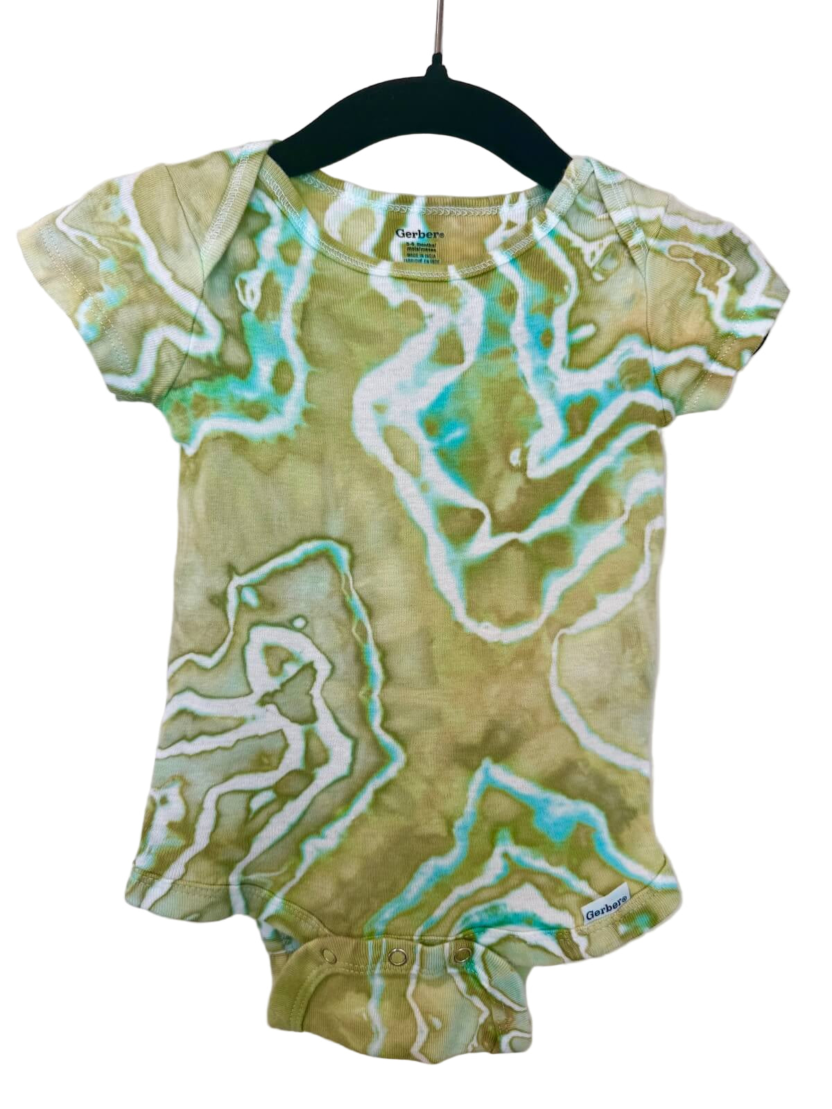 Front of green, turquoise and white patterned baby romper on a hanger against a white background