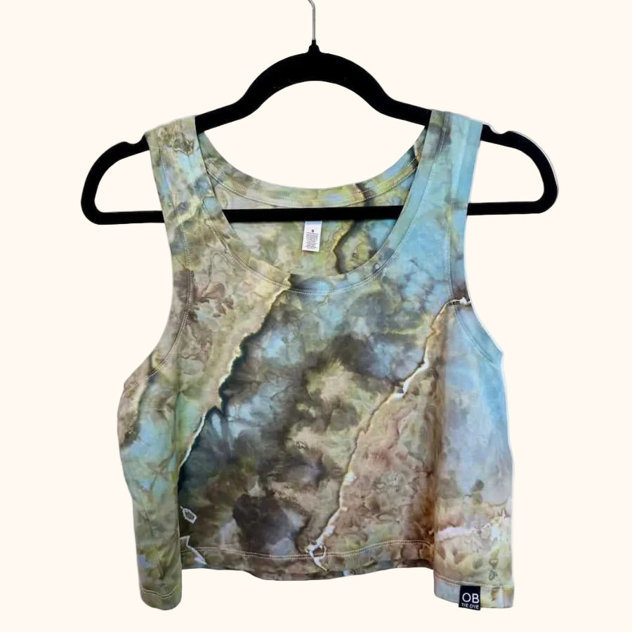 Front view of blue, green and earthy brown hand ice-dyed women’s crop tank on hanger