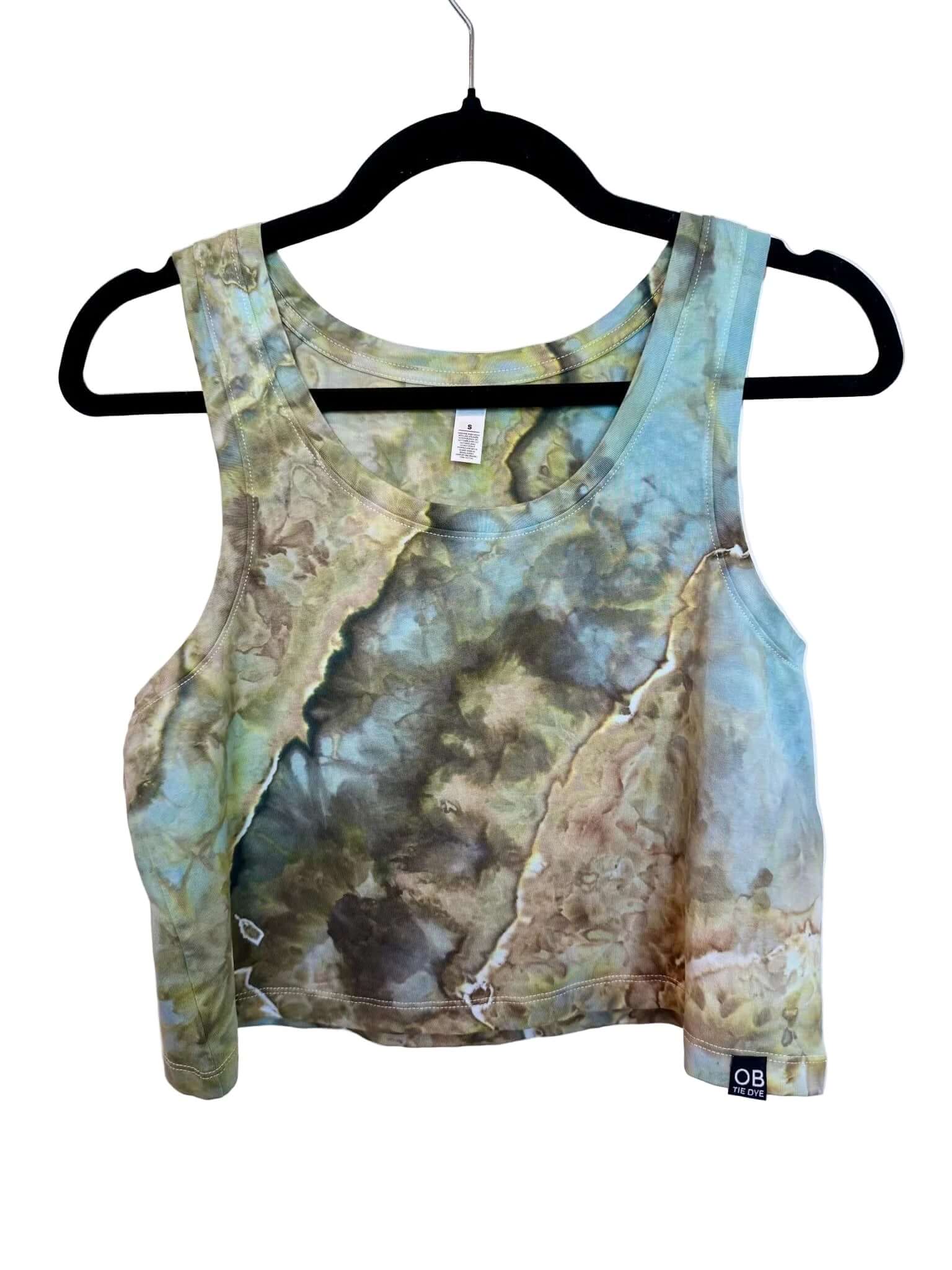 Front view of blue, green and earthy brown hand ice-dyed women’s crop tank on hanger