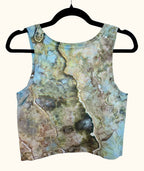 Back view of blue, green and earthy brown hand ice-dyed women’s crop tank on hanger