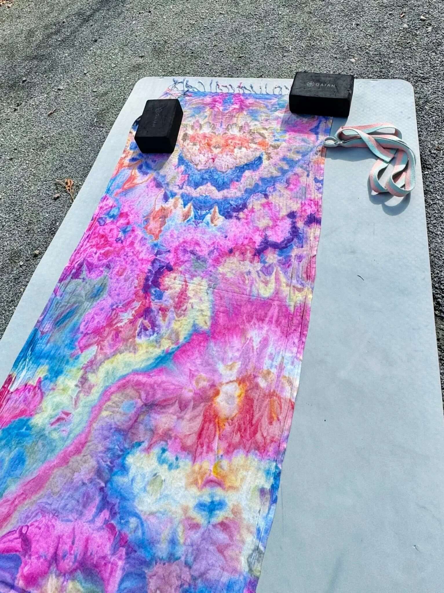 Colorful ice-dye yoga towel on a gray mat