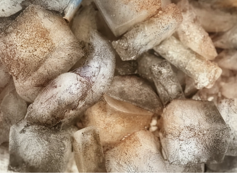 Close-up of ice melting dye into fabric in the OB Tie Dye studio, creating soft muted color patterns