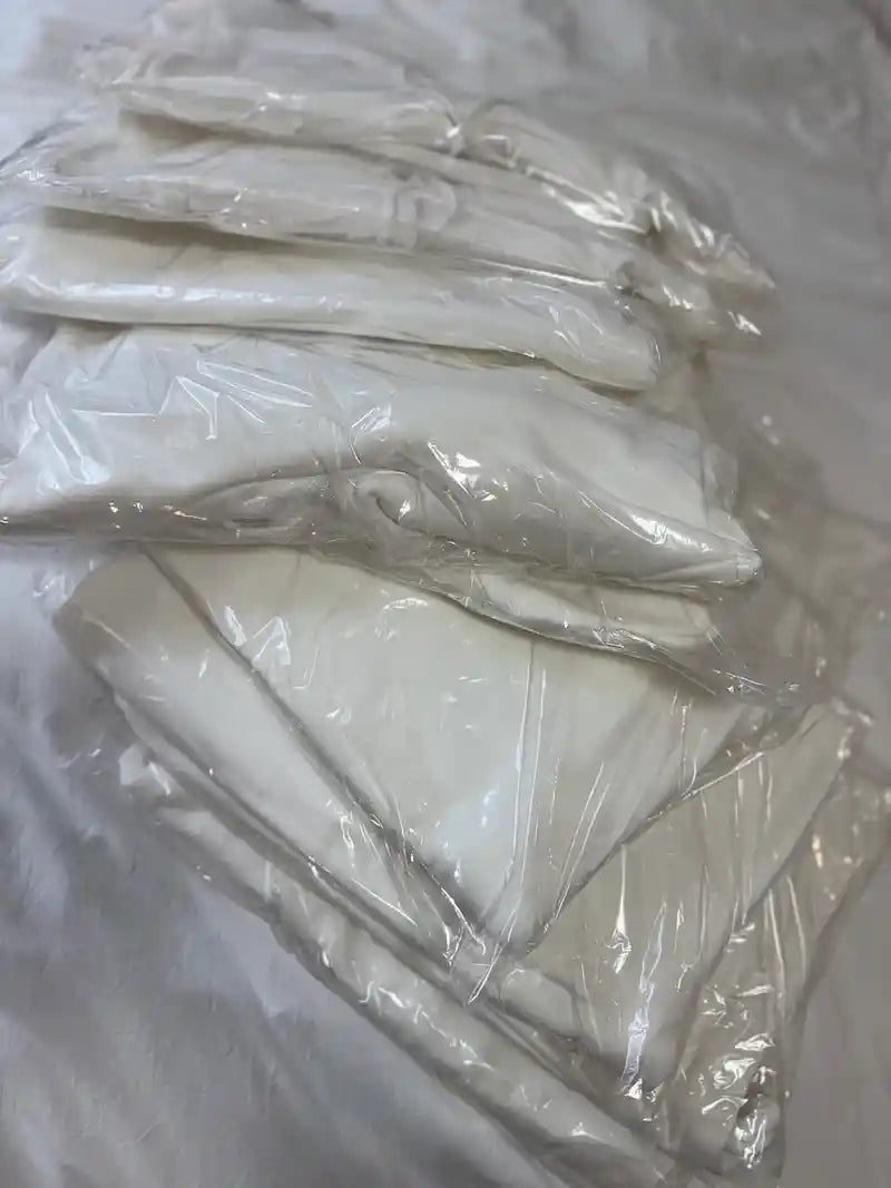 Neatly stacked premium blank garments sealed in bags before dyeing.