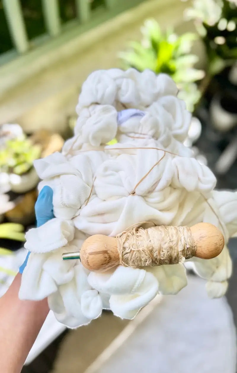 White garment scrunched and wrapped with sinew, ready for OB Tie Dye’s ice-dyeing technique.