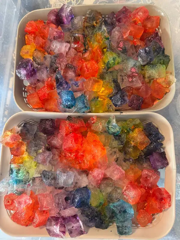 two ice dye batches of colorful ice with a rainbow of fiber reactive dye colors showing the ice dye process