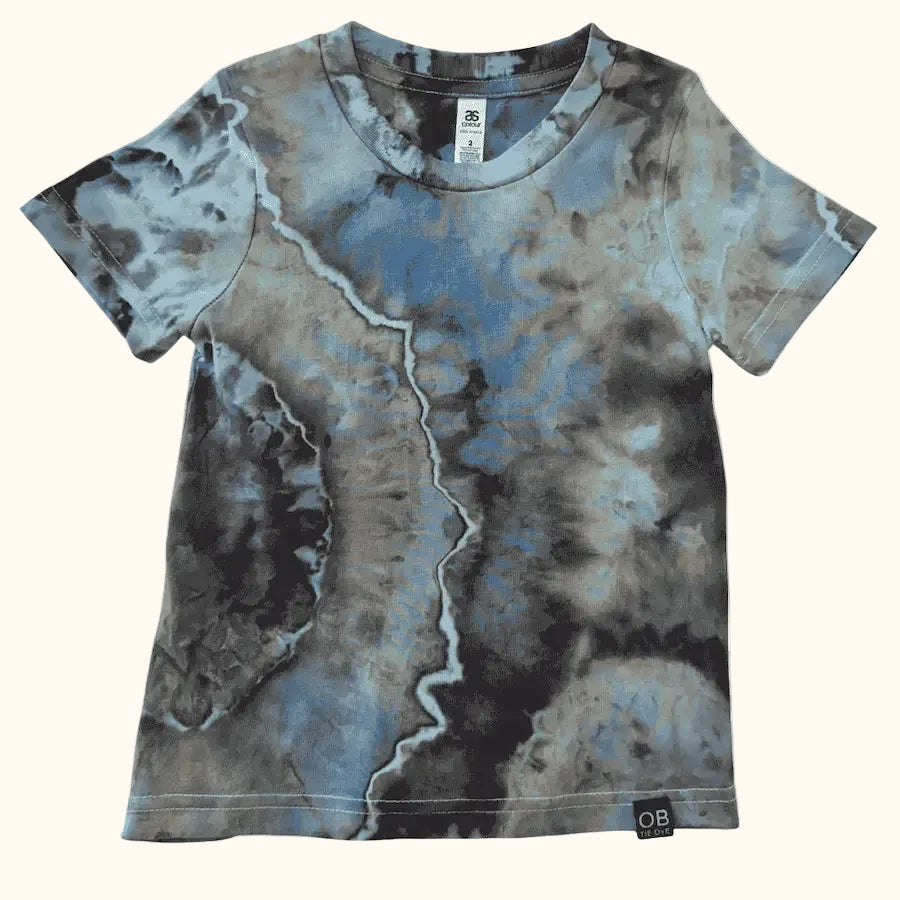 Front view of a kids’ OB Tie Dye shirt with blue, green, and brown geode-style ice-dye patterns.